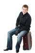 Businessman sitting on a suitcase.