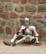 The knight in a heavy armor sits on the earth