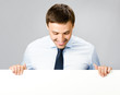 Business man showing blank signboard, over gray