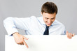 Business man showing blank signboard, over gray