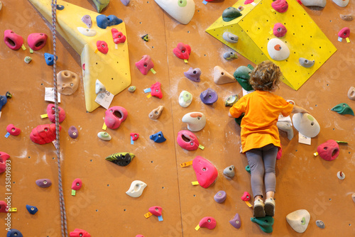Photo: Petite fille grimpant un mur d'escalade Petite fille grimpant un mur d'escalade