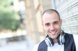 Foto: Smiling man listening to music in the street Smiling man listening to music in the street