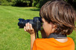 boy taking shots with photocamera in park