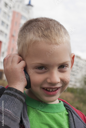 Photo: The little boy talks by a mobile phone The little boy talks by a mobile phone
