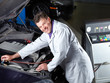 Motor mechanic tuning the engine of a car in a garage