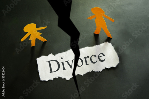 Photo: torn piece of paper with divorce text and paper couple figures torn piece of paper with divorce text and paper couple figures