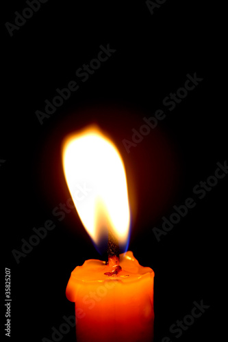 Foto: Closeup of burning candle on black background Closeup of burning candle on black background
