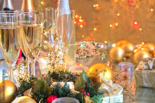 Photo: Champagne in glasses,baubles,candle lights. Champagne in glasses,baubles,candle lights.