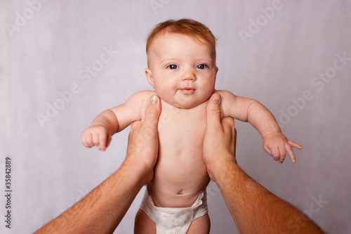 Photo: POV person holding baby with arms stretched POV person holding baby with arms stretched