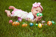 Photo: Baby girl laying in the grass with colored Easter eggs Baby girl laying in the grass with colored Easter eggs