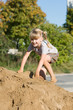 Mädchen klettert auf Sandhaufen