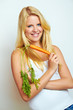 young blond woman with a fresh carrot