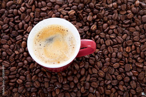 Photo: coffee cup in background of beans coffee cup in background of beans