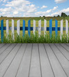 Wooden floor with, fence, green grass and blue sky
