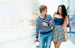 Portrait of young couple walking together at airport hall with t