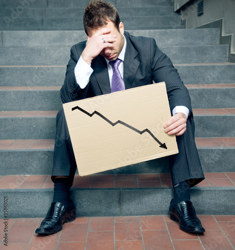 Foto: Desperate businessman showing negative graph Desperate businessman showing negative graph