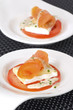Salmon rolls decorated with cheese and tomato