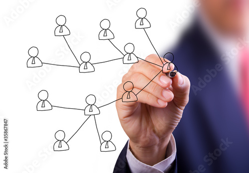 Photo: business man hand writing social network on whiteboard business man hand writing social network on whiteboard