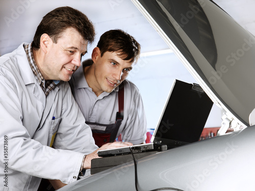 Foto: Master mechanics working with diagnostic computer Master mechanics working with diagnostic computer