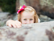 beautiful blonde little girl girl hides behind a stone beautiful blonde little girl girl hides behind a stone