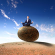 Businessman rolling a giant stone