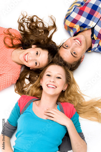 Photo: Three young friends lying down Three young friends lying down