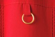 Goldener Schmuckring mit Lasche - Detail einer roten Bluse
