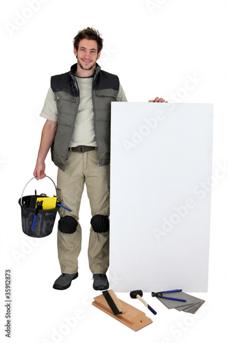 Photo: Handyman with a board left blank for your message Handyman with a board left blank for your message