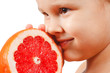 Little boy with a juicy pink grapefruit