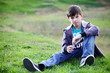 Foto: Boy in jeans sits on a grass Boy in jeans sits on a grass