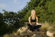 Eyes closed woman meditating yoga on rock