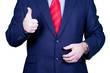 Businessman in suit and red tie hilding thumbs up.
