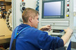 Foto: worker operating CNC machine center worker operating CNC machine center