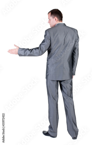 Photo: businessman extending hand to shake. Rear view. businessman extending hand to shake. Rear view.