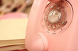 Photo: A pink rotary telephone on a desk. A pink rotary telephone on a desk.