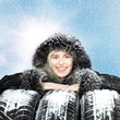 Smiling woman with warm coat and winter tires in the snow