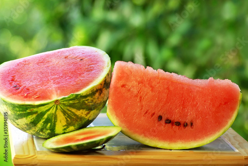 Photo: Watermelon and slice on table. Watermelon and slice on table.