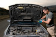 Photo: Adult man filling windshield washer reservoir. Adult man filling windshield washer reservoir.