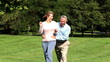 Happy elderly senior couple running  in park