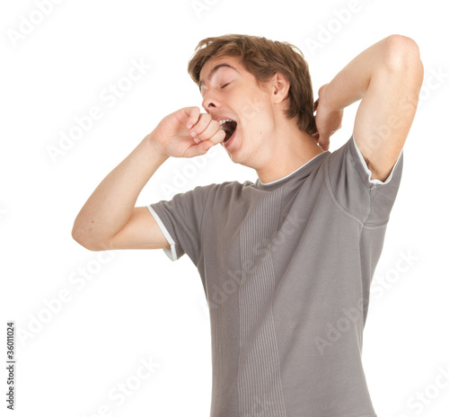 Photo: standing young tired man yawning and stretching standing young tired man yawning and stretching
