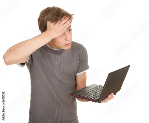 Photo: scared young man working on laptop, white background, series scared young man working on laptop, white background, series