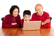Photo: Senior Asian grandparents using computer with their grandson Senior Asian grandparents using computer with their grandson