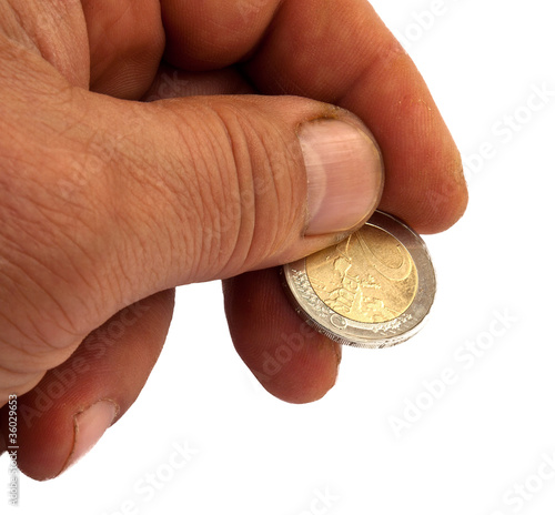 Photo: Hand with a two euro-coin isolated on white Hand with a two euro-coin isolated on white