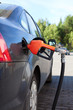 Refueling nozzle in the tank black car at fuel filling column