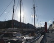 Pier with boats in Denmark. Sun shining through the ship's mast.