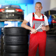 Foto: Motor mechanic in a garage next to a set of winter tyres Motor mechanic in a garage next to a set of winter tyres