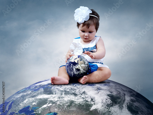 Photo: Child sitting on the Planet Earth with globes in hands Child sitting on the Planet Earth with globes in hands
