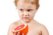Little boy with a pink grapefruit on a white background