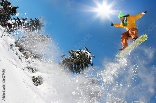 Photo: Snowboarder jumping against blue sky Snowboarder jumping against blue sky