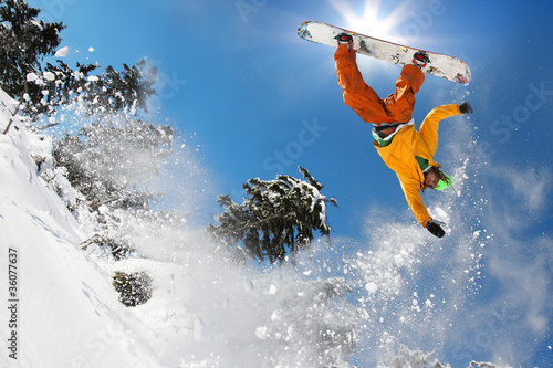 Photo: Snowboarder jumping against blue sky Snowboarder jumping against blue sky